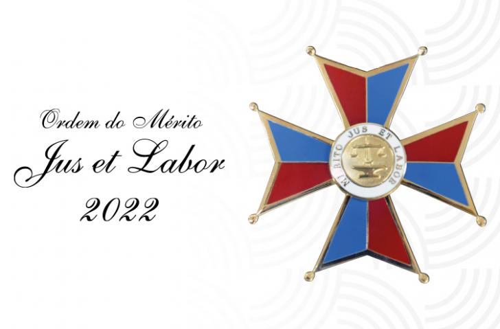 Arte com fundo branco. Ao lado esquerdo, o texto "Ordem do Mérito Jus et Labor 2022" em preto.