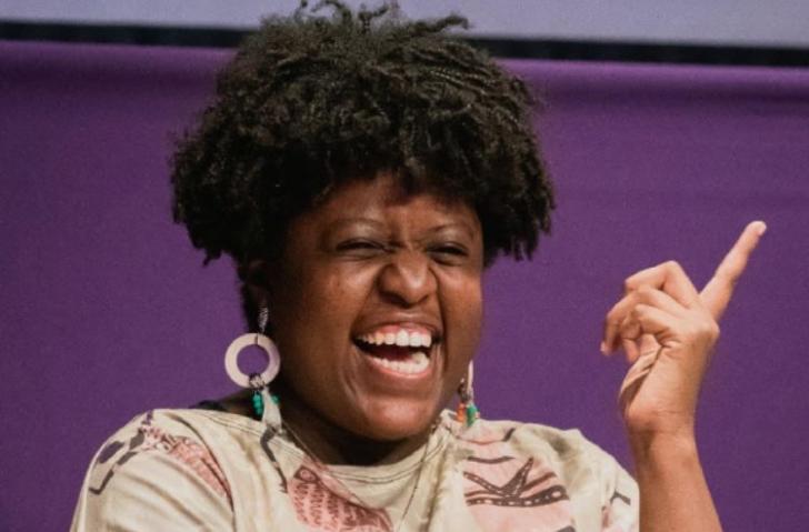 Mulher Negra, com cabelo curto, mas volumoso.
