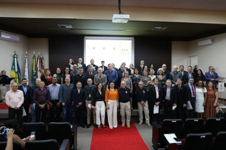 #ParaTodosVerem: Fotografia em ambiente fechado que reúne servidores(as), magistrados(as) em pé, sorrindo.