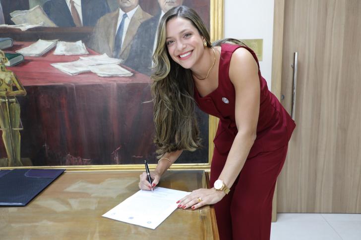 Foto da nova servidora do TRT8, Emanuelle Costa, durante a assinatura do termo de posse.