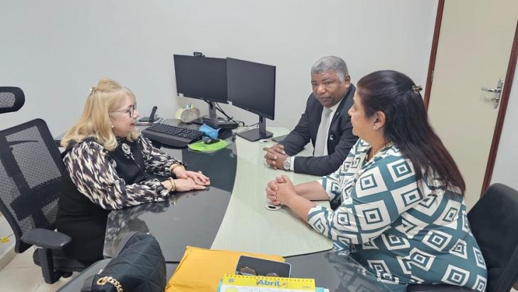Descrição de imagem: Fotografia em ambiente fechado com 3 pessoas, 2 mulheres e 1 homem.