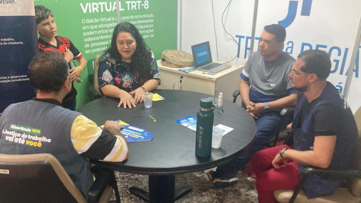 Foto de ambiente fechado que reune homens e mulheres realizando atendimento do TRT-8 na ExpoFeira