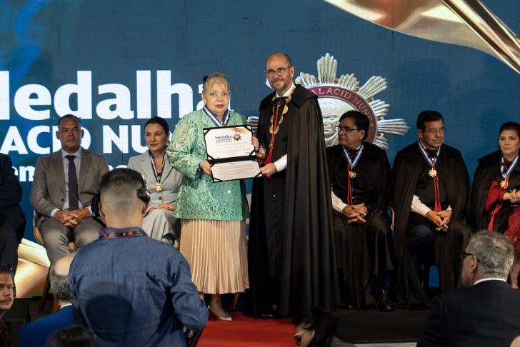 Foto em ambiente fechado mostrando a cerimonia solene de entrega da Medalha da Ordem de Mérito de Contas “Governador Alacid"