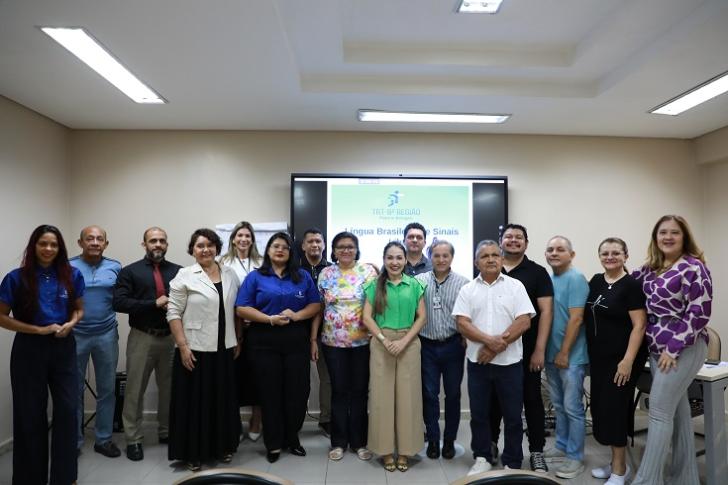 #ParaTodosVerem: fotografia colorida em ambiente fechado, reunindo homens e mulheres em pé sorrindo.— Foto: ASCOM8
