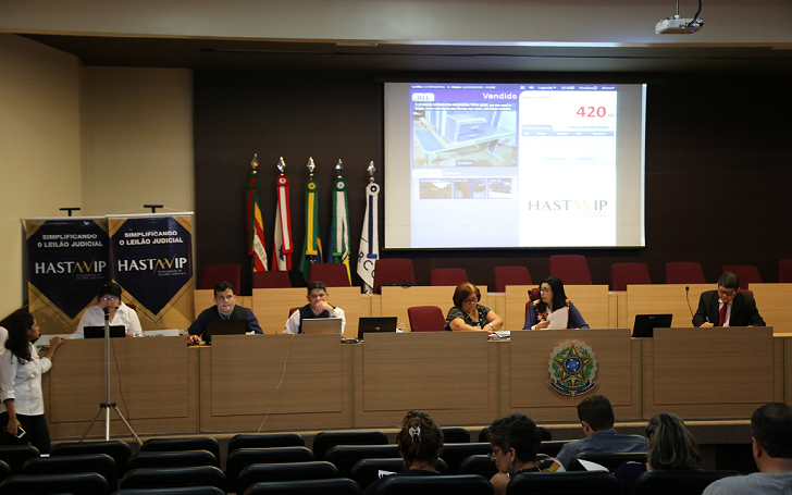 Foto do dos leiloeiros juntamente com servidores e a magistrada Nazaré Medeiros Rocha realizando o leilão no auditório do TRT8