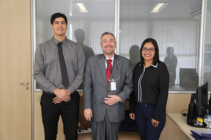 Foto dos novos servidores Duan da Silva Brito e Dayanne de Oliveira Gomes com o diretor-geral George Pitman.