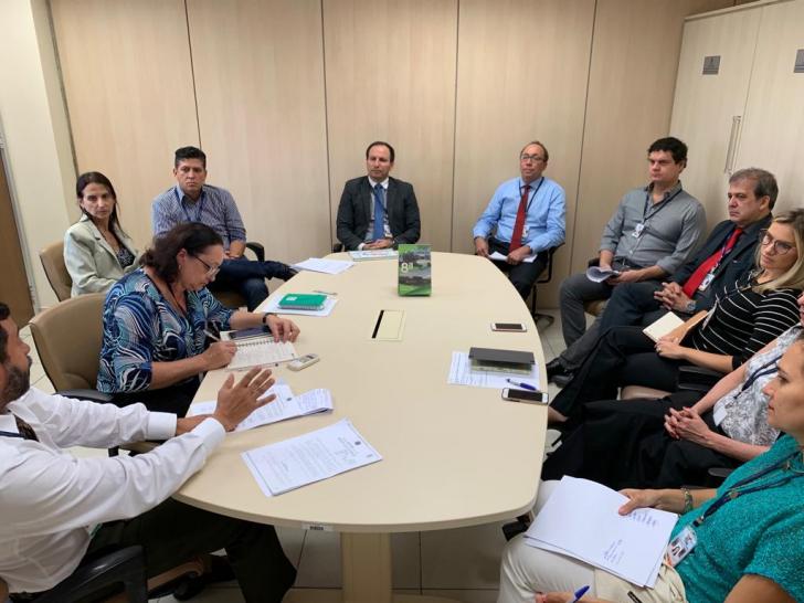 todos sentados em uma mesa discutindo assuntos da reunião.