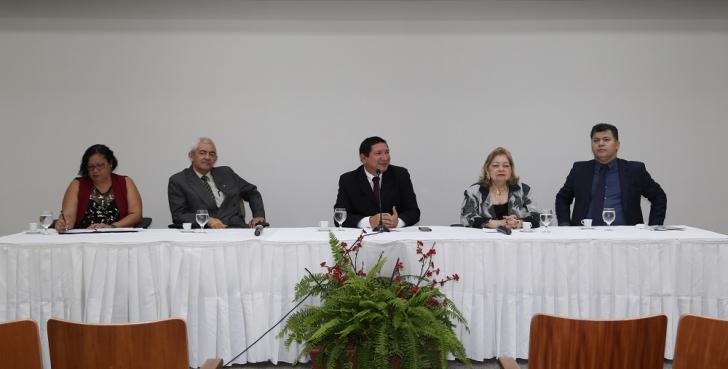 Convidados da mesa redonda sentados na mesa do auditório da EJUD