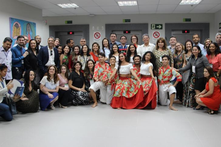 Foto feita no hall do auditório mostra os participantes do evento e os dançarinos do grupo de carimbó