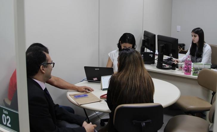 partes sentadas ao redor da mesa do CEJUSC tentando um acordo