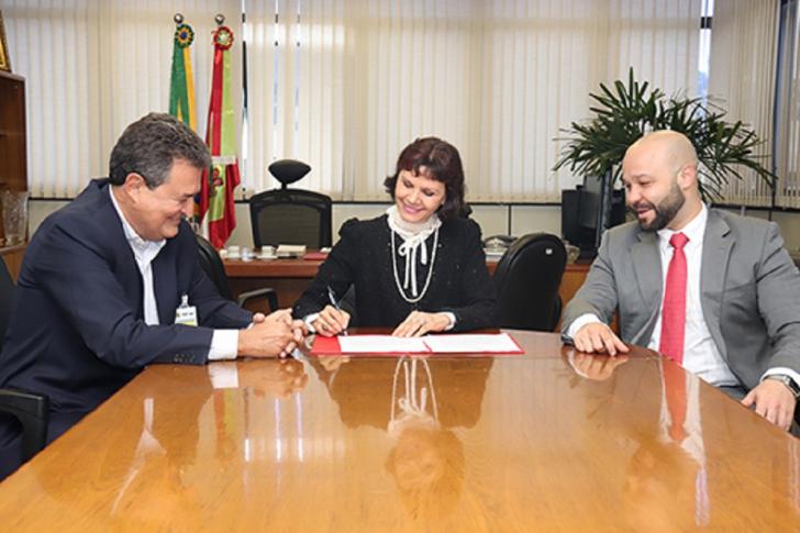 Carlos Fonseca (E) e desembargadora Mari Eleda durante assinatura do termo de cessão de uso, acompanhados pelo assessor jurídico