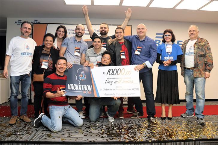 Na foto: Os ganhadores do segundo lugar segurando seu prêmio e os mentores