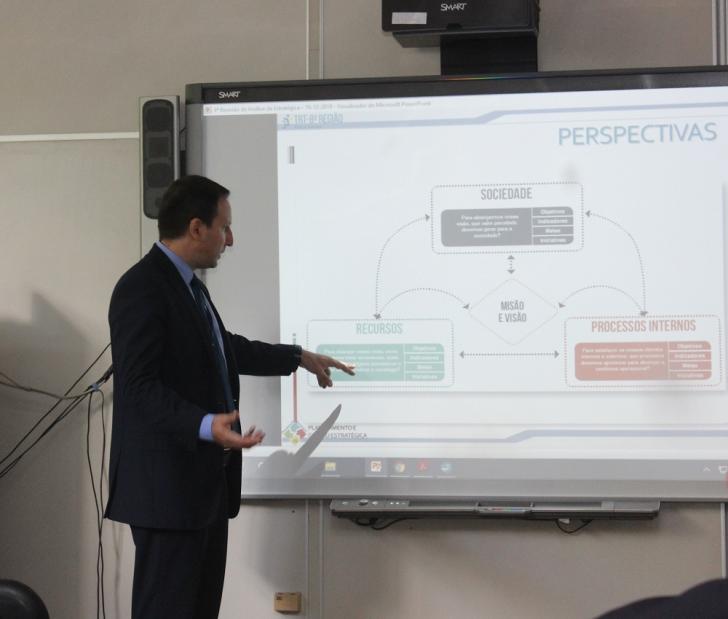 Coordenador de gestão estratégica, Rodopiano Neto, explicando os slides do planejamento estratégico para 2020.
