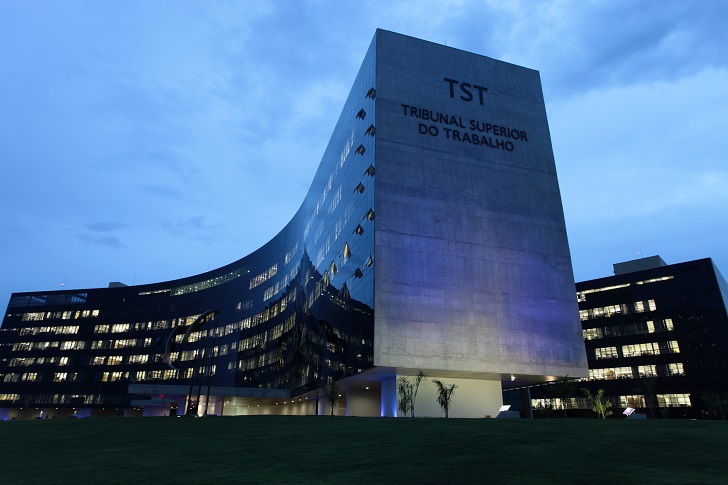 Foto noturna da fachada do Tribunal Superior do Trabalho, iluminada com refletores.