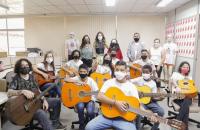 Imagem da turma da oficina de violão com a cantoria Lia Sophia, a desembargadora Zuíla Dutra, a juíza Vanilza Malcher