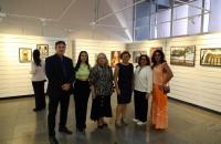 Foto da curadora com os fotogrado da exposição
