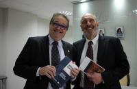 Desembargador Sérgio Rocha e o advogado Fernando Scaff. Dois homens de terno preto, cada um segurando um dos livros 