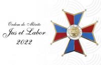 Arte com fundo branco. Ao lado esquerdo, o texto "Ordem do Mérito Jus et Labor 2022" em preto.