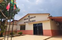 Em primeiro plano três postes pretos, ao fundo fachada da Vara do Trabalho de São Félix de Xingu. Parede bege com faixa laranja 