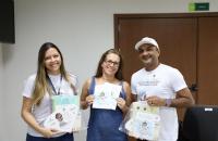 #Para todos verem: Três voluntários da Campanha do Círio do TRT-8. A esquerda uma voluntária, mulher branca, cabelos longos loir