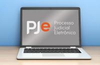 Notebook sobre a mesa com logo do PJe na tela.