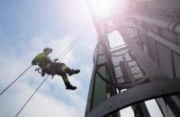 Trabalhador com equipamento de segurança fazendo rapel na Torre