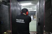 Fotografia em ambiente fechado que tem um policial judicial no curso de tiros