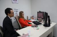 Fotografia em ambiente fechado de uma audiência telepresencial. 