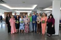 Fotografia em ambiente fechado que reúne homens e mulheres, lado a lado, em pé