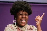 Mulher Negra, com cabelo curto, mas volumoso.