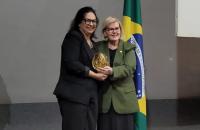 Foto em ambiente fechado. Ao centro, duas mulheres. A direita, a ministra Rosa Weber, do lado esquerdo, a juíza Elinay Almeida.