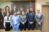 Fotografia em ambiente fechado que reúne quatro homens e uma mulher.