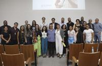 Fotografia em ambiente fechado que reúne dezenas de pessoas sorrindo e em pé