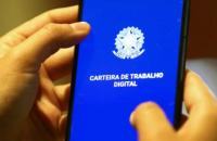 Fotografia fechada em duas mãos segurando um celular. O celular mostra uma tela toda azul 