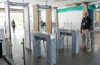 Foto colorida tirada com a perspectiva de dentro do prédio do TRT8 para fora, mostrando duas portas detectoras de metal e duas c