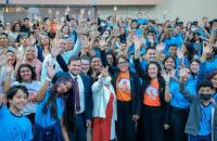 Foto de abertura, mostra as crianças atendidas pelo projeto, todas de pé, juntas, de braços levantados em celebração.