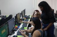 Fotografia em ambiente fechado que reúne quatro mulheres no laboratório de informática