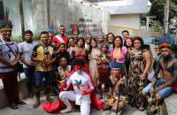 Fotografia colorida de um grupo de indígenas, homens, mulheres e crianças, junto com servidores e magistrados do TRT-8, posando 