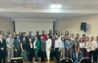 Fotografia colorida da Corregedora do TRT8, a desembargadora Maria Zuíla Dutra com os servidores (as). O fundo da foto é neutro.