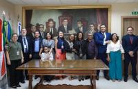 Fotografia colorida. Servidores do TRT-8, os novos empossados e seus familiares reunem-se para foto na antessala da presidência