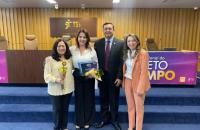 Foto colorida de quatro pessoas de pé no auditório do TST. À esquerda, representantes do TRT-8 seguram certificado de premiação.