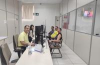 #ParaTodosVerem: Fotografia colorida em ambiente fechado. Na foto está presente cinco pessoas sentadas, todas estão sorrindo.