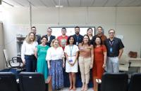 Foto colorida do grupo que participou do workshop reunido, de pé, no auditório da Ecaiss.