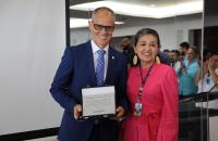 Foto colorida do presidente marcus augusto losada e a diretora geral durante a entrega da placa celebrativa da gestão 22-24