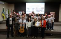 Fotografia que reúne dezenas de pessoas entre homens, mulheres e crianças da Cantata de Natal