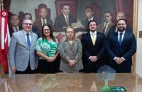 Foto colorida. Direção da escola judicial e do trt8 se reunem para foto com o empossado.