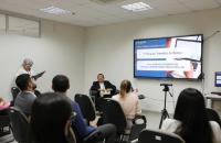 Foto colorida da sala de conferências da EJUD. À frente, sentado, o corregedor regional. Diante dele, magistrados e servidores.