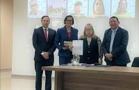 Foto colorida. Lado a lado, o diretor Rodopiano Neto, a juíza Núbia Guedes e os desembargadores Sulamir Monassa e Luís Ribeiro.