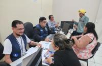 Foto colorida da sala de atendimento do TRT8 durante itinerância em Afuá. Três pessoas são atendidas por servidores.