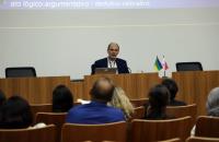 Foto do palestrante no auditório da EJUD8 enquanto fala aos participantes.